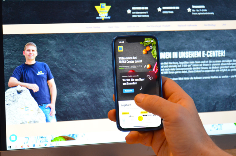 EDEKA App auf dem Smartphone mit der Lunze-Webseite im Hintergrund