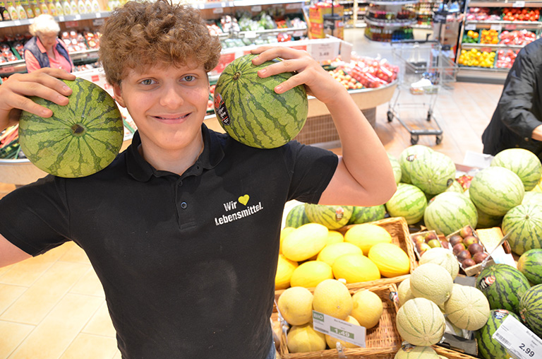 Mitarbeiter des E-Centers Lunze präsentiert die große Melonenvielfalt.