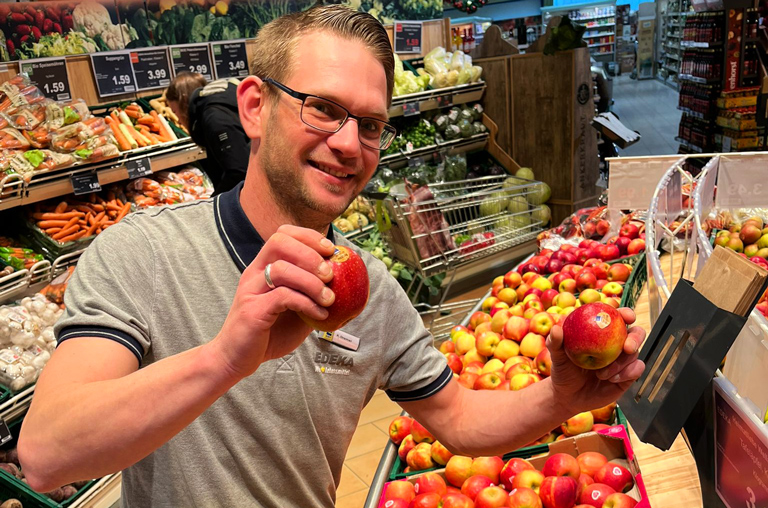 Abteilungsleiter Kevin Bremer mit dem neuen EDEKA-Apfel