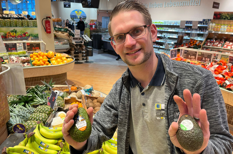 Abteilungsleiter Kevin Bremer mit zwei Sorten Avocado in der Hand.